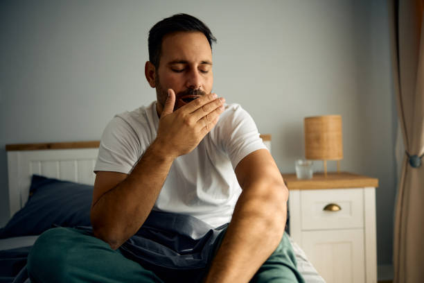 istock Exhausted man yawning on bed in the morning. 2177911610