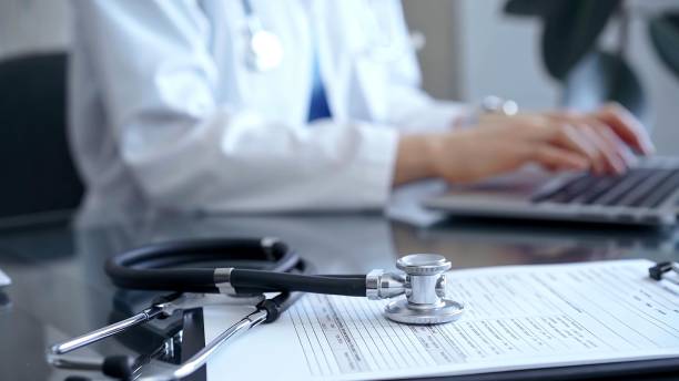 istock Stethoscope and medication record form are on the table besides the working doctor. Workplace in Medicine and Health care 2177912431