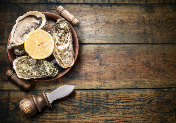 istock Raw oysters on the old wooden table. 2177914858