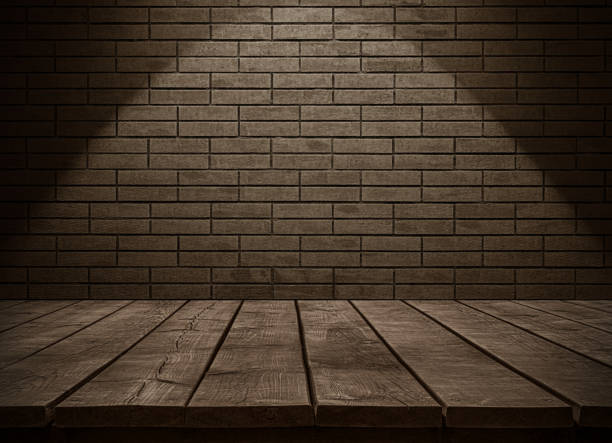 Empty wooden table top and grungy dark brick wall copy space scene