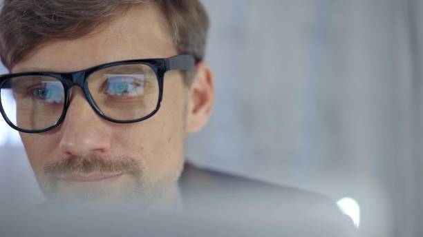 istock Businessman with glasses looking intently obscured partially by a translucent surface of laptop. Business concept 2177917266