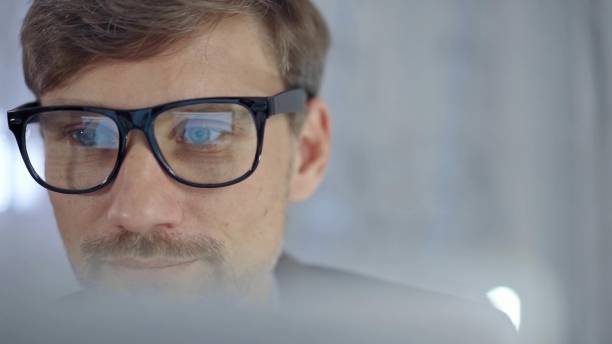 istock Businessman with glasses looking intently obscured partially by a translucent surface of laptop. Business people concept 2177917408