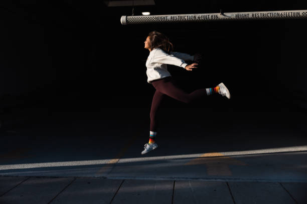 istock Young woman jumping agains a black background 2177919219