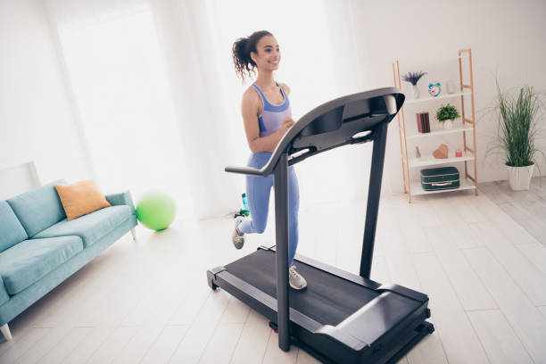 istock Young woman enjoying a treadmill workout in modern home interior with natural light 2177920749