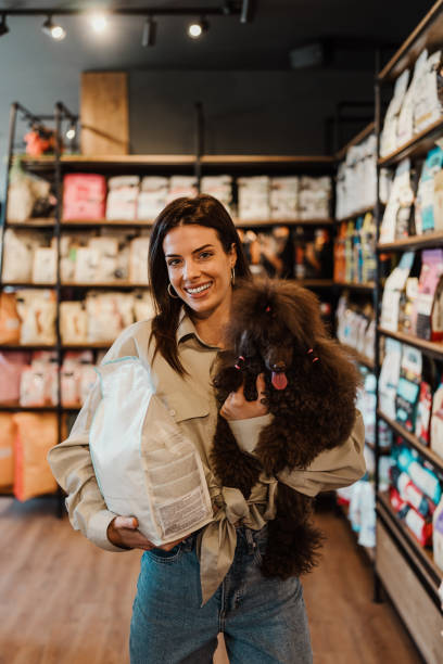 istock Young woman with poodle in pet shop 2177921005