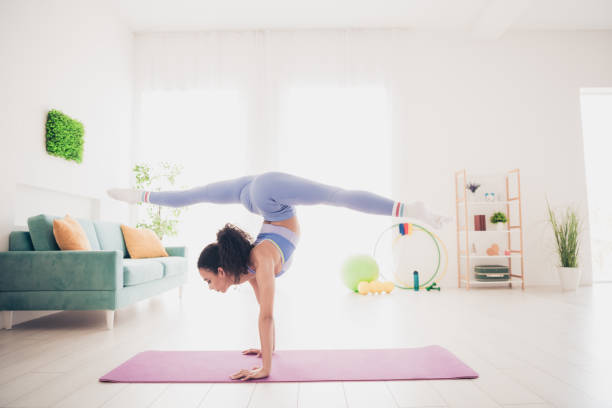 istock Young woman practicing advanced yoga pose in bright modern home interior with natural light 2177921205