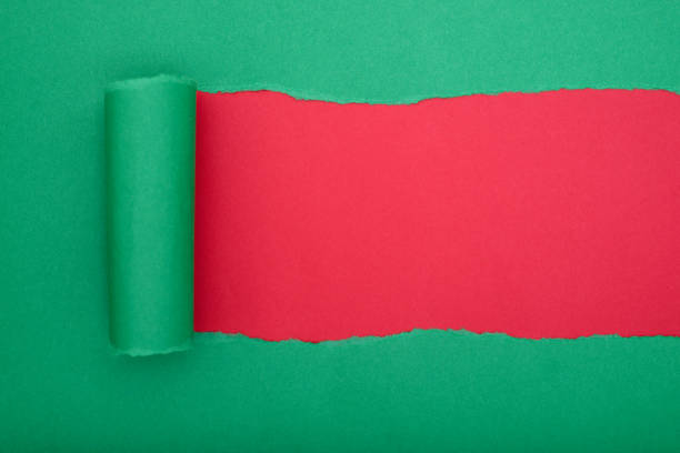 istock Torn green paper revealing a red background. Space for text. 2177923132