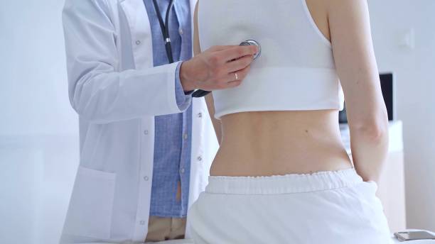 istock Doctor man using stethoscope examining female patient lungs duri 2177923978