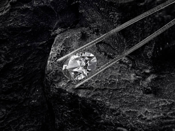istock Cut Beautiful diamond held by tweezers on black coal background 2177924823