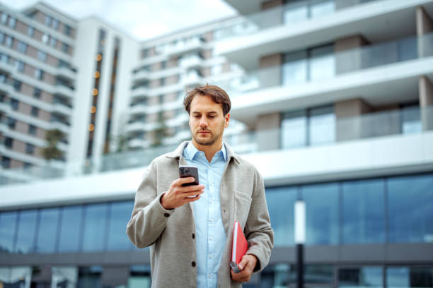 istock Handsome well dressed businessman using smart phone outdoors 2177928466