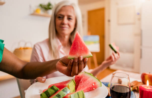 istock Friends sharing watermelon slices during christmas dinner at home 2177928897