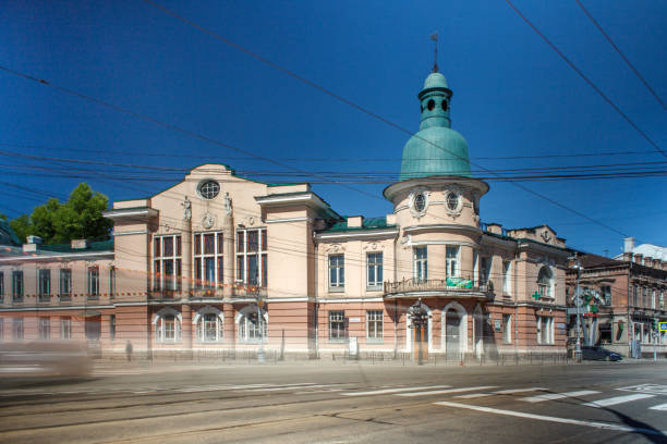 istock This photograph showcases a historic building with elegant architecture. The structure has a light pink façade with white detailing, large arched windows, and a prominent dome roof painted in a distinctive green hue. 2177929157