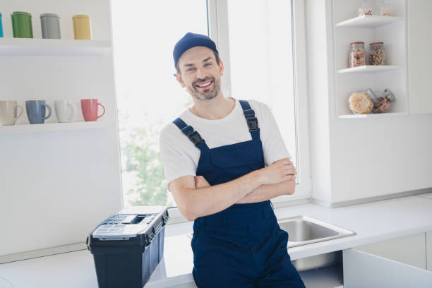 istock Smiling handyman in blue overalls standing confidently in bright kitchen with toolbox ready for home renovation tasks 2177929378