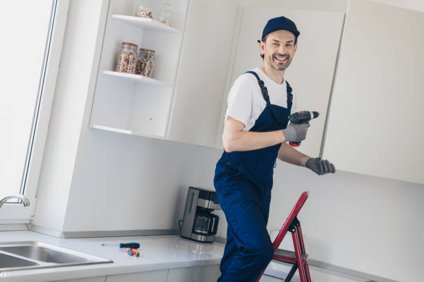 istock Young handyman with drill renovating kitchen, smiling confidently in blue overalls 2177929565