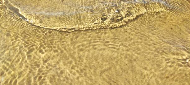 istock Small waves, ripples on the surface of water, with sand underneath. 2177931330