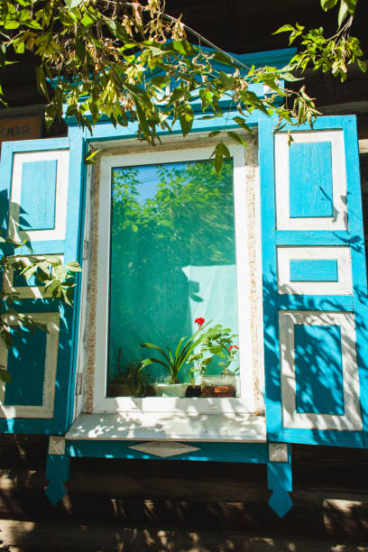istock Charming wooden window with blue shutters, adorned with plants on a sunny day 2177931459