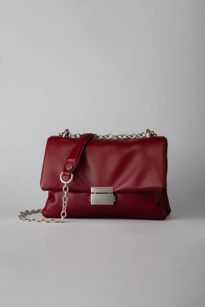 istock Deep red leather handbag or clutch on grey background 2177933275