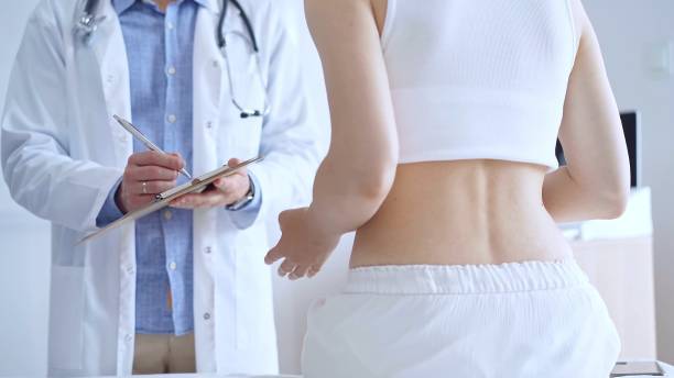 istock Doctor man is making notes on a clipboard while patient woman is describing back pain. Medicine and orthopedics concepts 2177934237