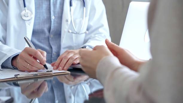 istock Doctor man is making notes while consulting patient with clipboard and a pen in his hand in medical office. Trust concept in Medicine 2177934593