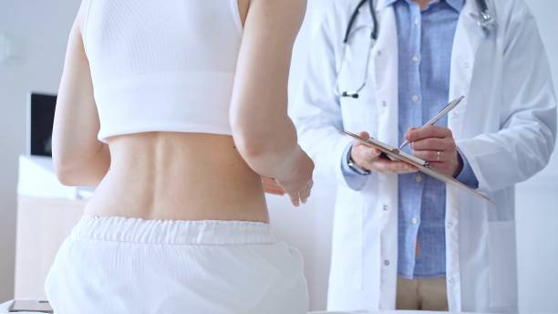 istock Doctor man is making notes on a clipboard while patient woman is 2177935185