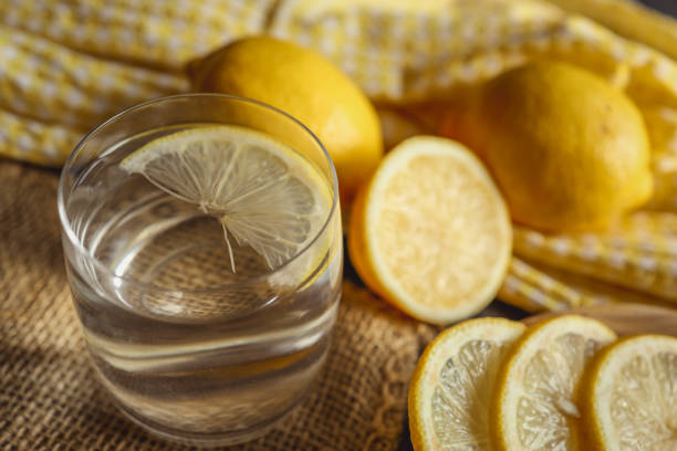 Cool freshly made lemonade in glass on wooden table. Space for text.