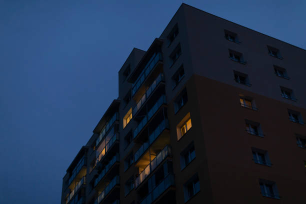 A tall and impressive building featuring numerous windows is beautifully illuminated at night, creating a stunning urban scene