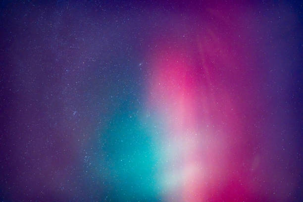 A purple and blue sky with stars. The sky is purple and blue with a greenish tint. An aurora borealis.