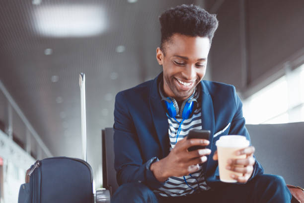 istock Young man waiting at the airport lounge using mobile phone 2177948489