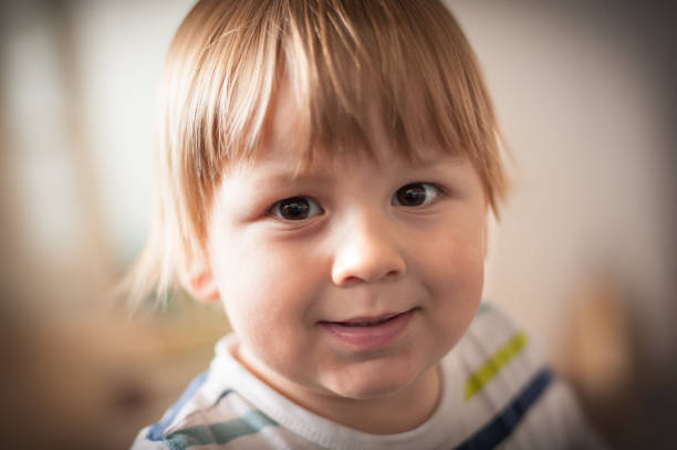 istock Young child smiling warmly in a cozy indoor setting during daylight, showcasing expressive eyes and playful demeanor 2177948627
