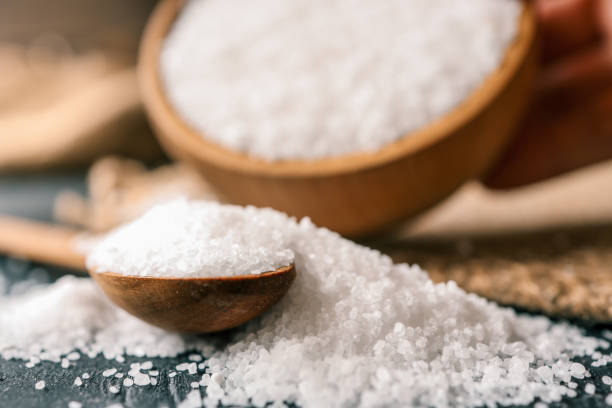 istock Pour salt into a wooden spoon, close-up 2177952462