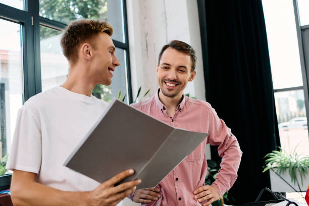 istock Young gay couple collaborating in a modern office space during a creative work session 2177953663