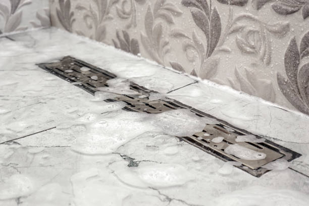Close-up of water and foam not flowing out of bathroom shower stall. Maintenance and care of plumbing fixtures in the home. Maintenance and care of plumbing in the house.
