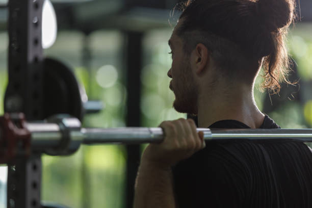 istock muscular man is exercising and lifting weights exercise. Increase arm and shoulder muscles. weightlifting training in squat workout. 2177955324