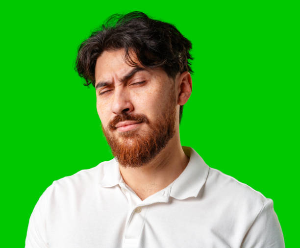 istock A young man with a beard showing a serious expression against a vibrant green background 2177956562