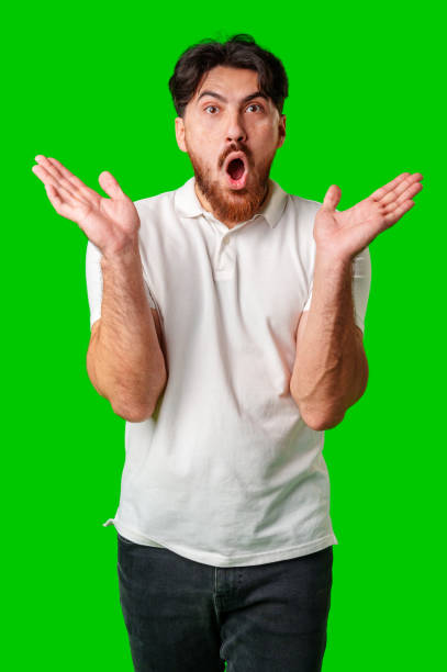 istock Young man expresses surprise in front of a bright green background 2177957784