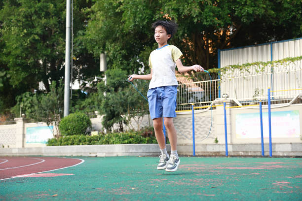 A little boy jumping rope on the playground