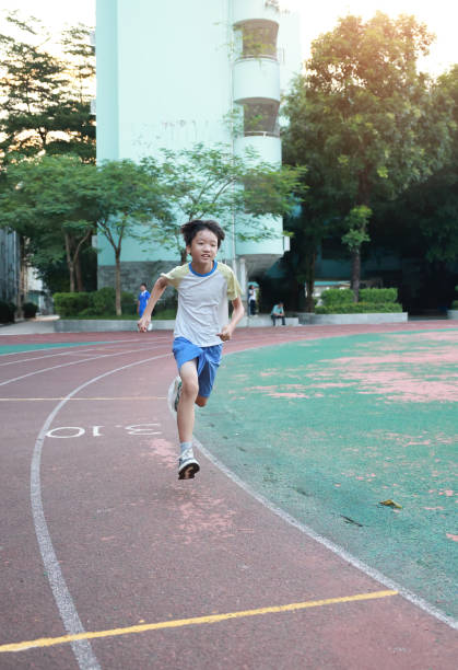Two Asian boy running and training on the track in stadium