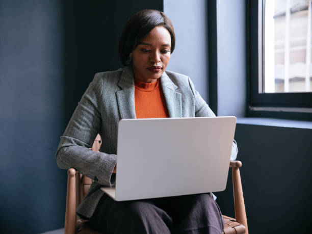 istock Focused Businesswoman Working Remotely on Laptop by Window 2177969672