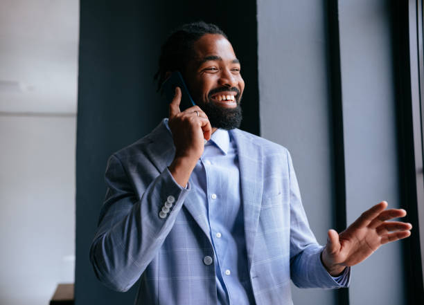 istock Smiling Businessman Talking on Mobile Phone Near Office Window 2177969733