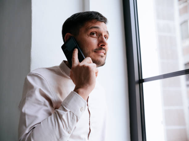 istock Confident Businessman Talking On Smartphone Near Office Window 2177969746