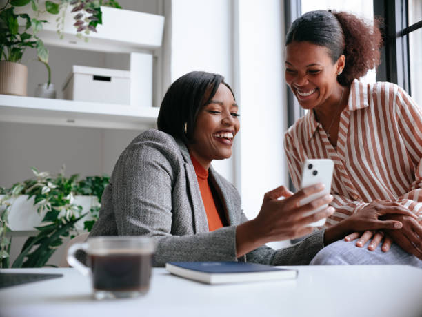 istock Happy Colleagues Sharing a Moment Using Smartphone in Office 2177969775