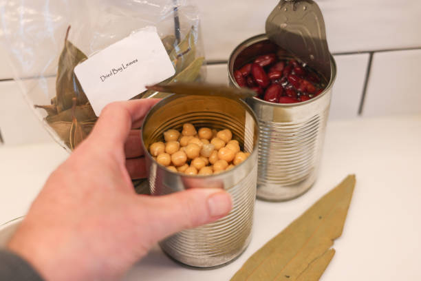Hand holding an open can of chickpeas