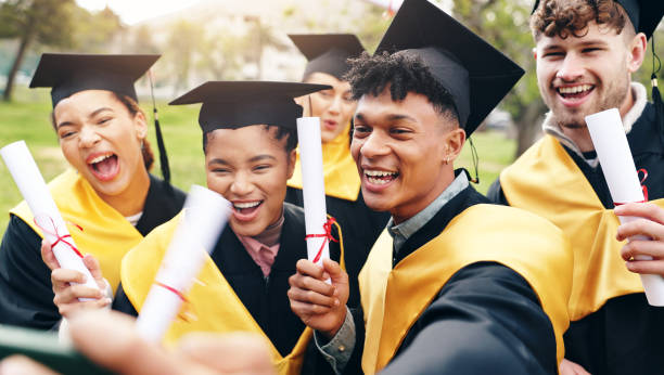 istock Selfie, happy and students at university graduation with degree certificate for education achievement. Excited, diploma and group of friends with photography picture for memory of college goals. 2177973322