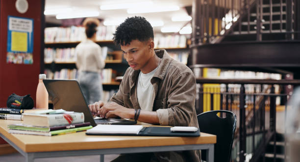 istock Reading, laptop and research with man in library for knowledge, education and college thesis. Academy, future and university with student and studying on campus for exam, project and scholarship 2177975173