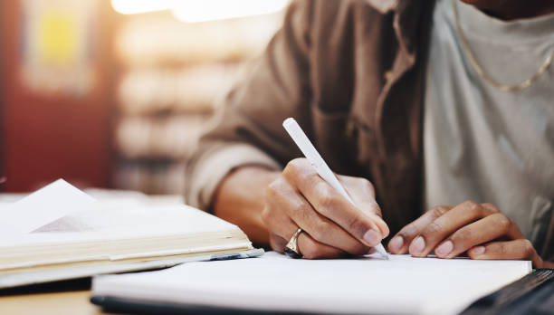 istock Hands, writing and books with person in library for knowledge, education and college thesis. Academy, future and university with student and studying on campus for exam, project and scholarship 2177975207