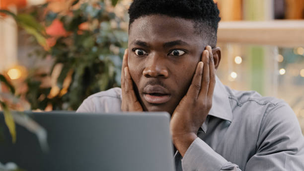Close-up young businessman looking at laptop screen getting bad news surprised shocked man holding head found error incorrectness in electronic document virus in application loss important information. High quality 4k footage primer plano, joven hombre de negocios que mira la pantalla de la computadora portátil recibiendo malas noticias, sorprendido, hombre conmocionado que sostiene la cabeza, encontró error, incorrección en el documento electrónico, virus en la pérdida de