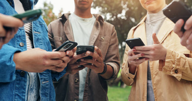 istock Students, hands and phone outdoor with social media, text and scroll for meme in group on campus. University, garden and college ground with mobile app, streaming and online course with friends 2177975567