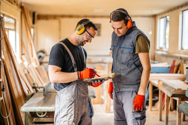 istock Two Young Male Carpenter Checking Measurements Written In The Notebook In The Workshop 2177976318