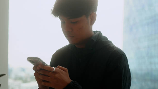 istock Asian man using smartphone with Bangkok city scape view. 4K. 2177979256