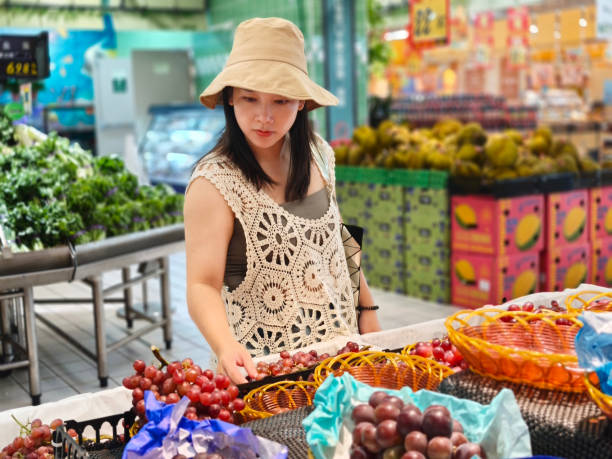 istock Woman choosing grape in greengrocer 2177980143